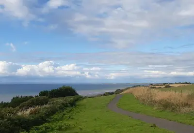 a winding road on top of a hill with the ocean at Harbour Side in Maryport