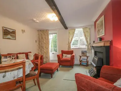 a living room with red walls and a fireplace at Derwent Edge in Portinscale