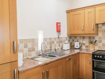 a kitchen with wooden cabinets and a sink at Skiddaw in Cockermouth
