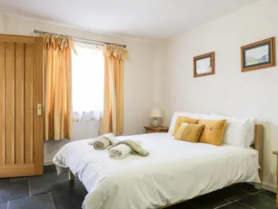 a bedroom with a large white bed with towels on it at Skiddaw in Cockermouth
