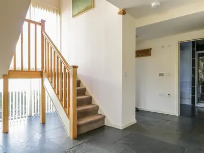 a staircase in a home with white walls at Beckside in Cockermouth