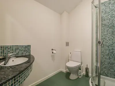 a bathroom with a toilet and a sink and a shower at Beckside in Cockermouth