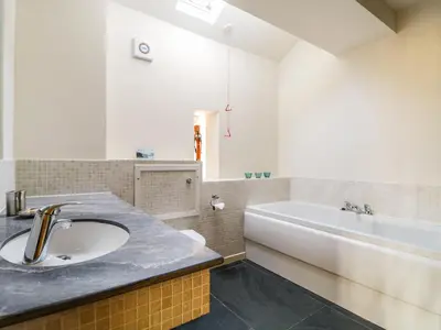 a bathroom with a sink and a bath tub at Beckside in Cockermouth