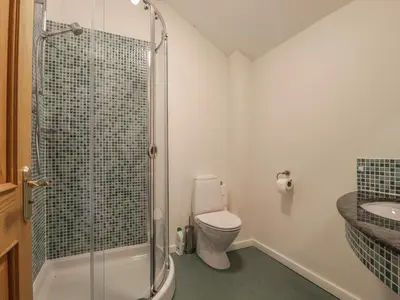 a bathroom with a shower and a toilet and a sink at Beckside in Cockermouth