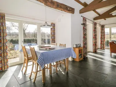 a dining room with a blue and white table and chairs at Buttermere in Cockermouth