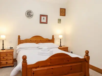 a bedroom with a wooden bed with white pillows at The Hayloft in Keswick