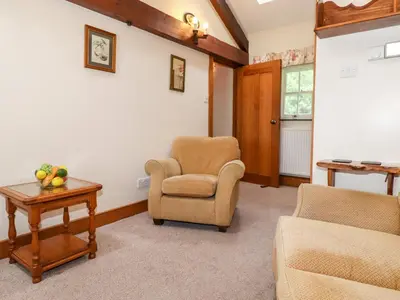 a living room with two chairs and a table at The Hayloft in Keswick