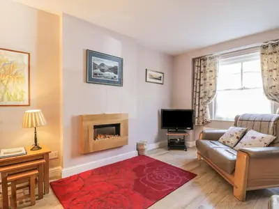 a living room with a couch and a fireplace at Swinside Cottage in Keswick