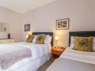two beds sitting next to each other in a bedroom at Swinside Cottage in Keswick