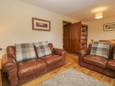 a living room with two brown leather couches at Tanner Croft Cottage in Ambleside