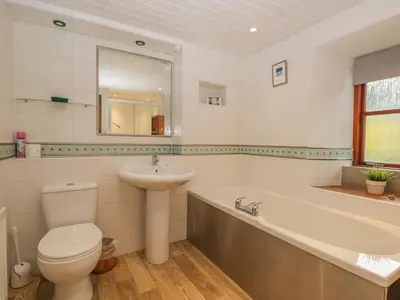 a bathroom with a toilet and a sink and a tub at Tanner Croft Cottage in Ambleside