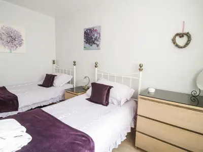 two beds in a room with white walls at Manesty View in Keswick