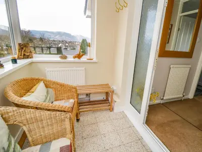 a room with a chair and a table and a window at Manesty View in Keswick