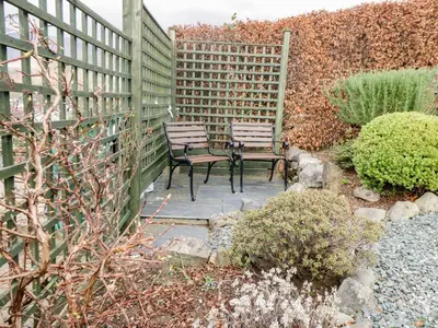 two benches sitting on a patio in a garden at Manesty View in Keswick