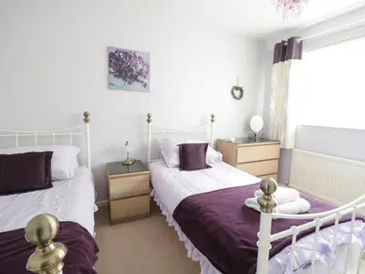 a bedroom with two beds and a window at Manesty View in Keswick