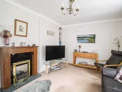 a living room with a fireplace and a tv at Manesty View in Keswick