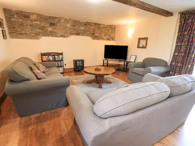 a living room with two couches and a tv at Tithe Cottage in Cockermouth