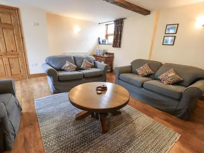 a living room with couches and a coffee table at Tithe Cottage in Cockermouth