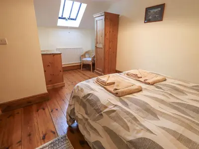 a bedroom with a bed with two towels on it at The Byre in Cockermouth