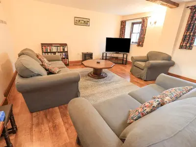 a living room with two couches and a television at The Byre in Cockermouth