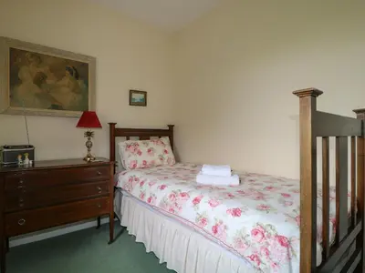 a bedroom with a bed and a dresser and a painting at Dale House in Cockermouth