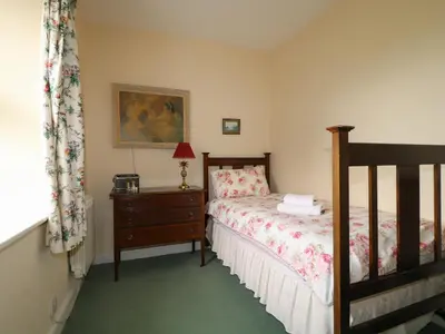 a bedroom with a bed and a dresser with a lamp at Dale House in Cockermouth