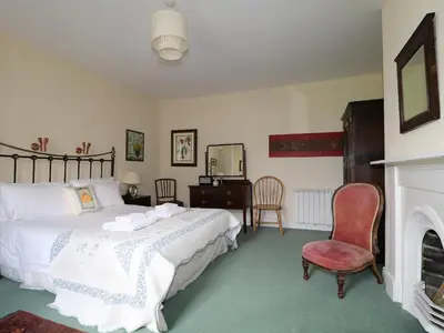 a bedroom with a bed and a fireplace at Dale House in Cockermouth
