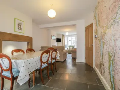 a dining room and living room with a table and chairs at Roselea in Keswick