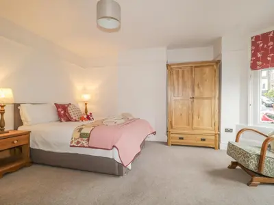 a bedroom with a bed and a wooden cabinet at Roselea in Keswick