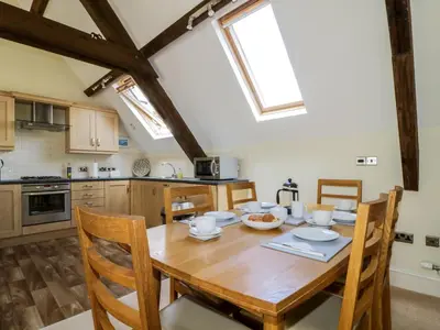 a kitchen with a wooden table and chairs in a kitchen at Carpenters Cottage in Cockermouth