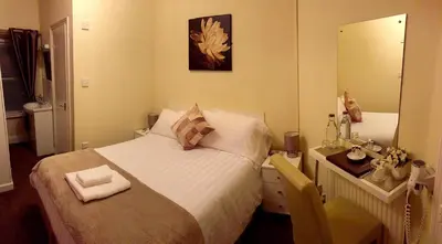 a small bedroom with a bed and a mirror at Lyndhurst in Keswick