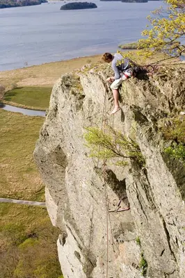 a person climbing on the side of a rock at Lyndhurst in Keswick