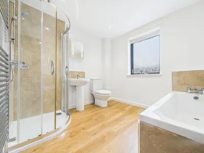 a bathroom with a shower and a sink and a toilet at Aura in Keswick