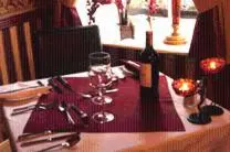 a table with a bottle of wine and a glass at The Cross Keys Hotel in New Galloway
