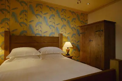 a bedroom with a large bed with a floral wallpaper at Moss Grove Organic in Grasmere