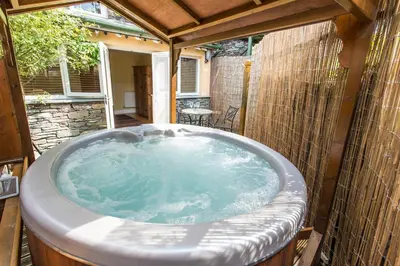 a jacuzzi tub in the backyard of a house at Moss Grove Organic in Grasmere
