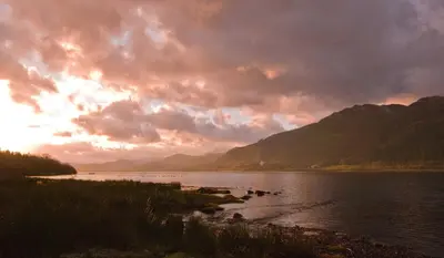 a sunset over a body of water with mountains at Ravenstone Lodge Country House Hotel in Keswick