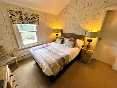 a bedroom with a bed and a window at Ravenstone Lodge Country House Hotel in Keswick