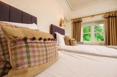 a bedroom with two beds with pillows and a window at Ravenstone Manor in Keswick