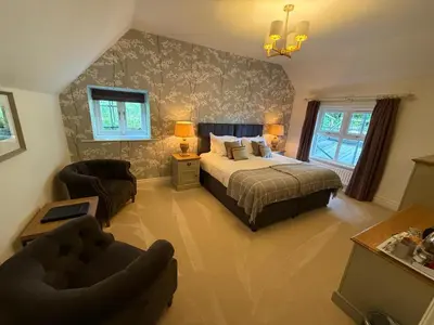 a bedroom with a bed and a couch and a chair at Ravenstone Manor in Keswick