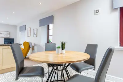 a dining room with a wooden table and chairs at Elliot Suite No2 - Donnini Apartments in Ayr