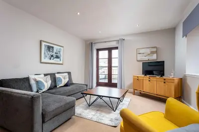a living room with a couch and a tv at Elliot Suite No2 - Donnini Apartments in Ayr