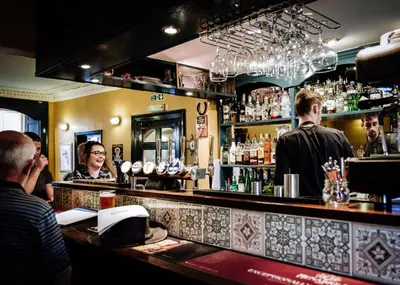 a group of people sitting at a bar at The Garret Hotel in Kirkcudbright