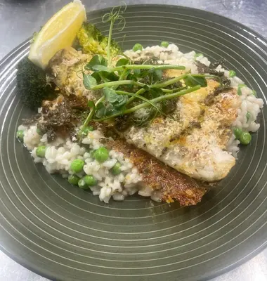 a plate of food with fish and rice and broccoli at The Garret Hotel in Kirkcudbright