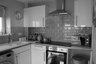 a kitchen with white cabinets and a stove top oven at No27 Ayr Beach - Coorie Doon Stays in Ayr