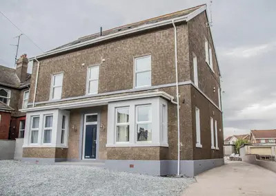 a brick house with white windows on a driveway at Keld Green House in Seascale