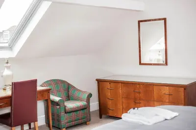 a bedroom with a dresser and a chair and a mirror at Keld Green House in Seascale