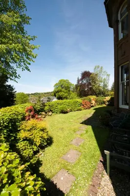 a garden with a walkway next to a house at Warriston Apartment at Holm Park in Moffat
