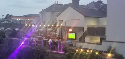 a group of people sitting on the balcony of a house at The Birchtree Hotel in Dalbeattie