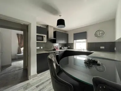 a kitchen with a table and chairs and a clock at Apartments No. 19 in Portpatrick